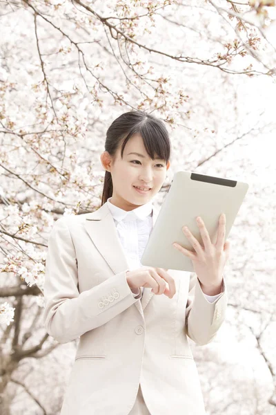asian woman using tablet  in park