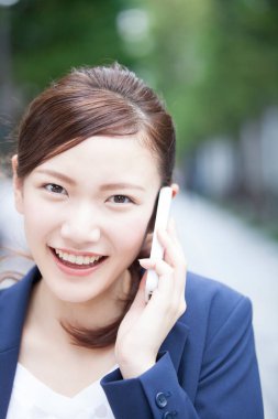 Japon kadın cep telefonuyla konuşuyor.