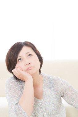 Kanepede oturan kadın düşünüyor 