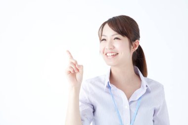 Gülümseyen genç bir kadın, parmağıyla işaret ediyor. 