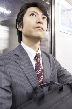 Yetişkin Japon iş adamının portresi metroda çalışacak.