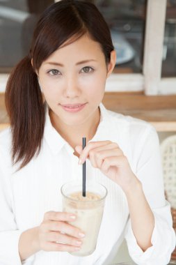Kafede kahve içen genç Japon kadın.