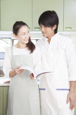 Gülümseyen genç çift yemek pişiriyor