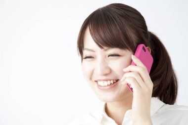 Stüdyoda izole edilmiş genç Asyalı kadın telefonda konuşuyor. 