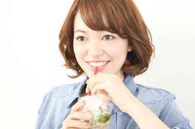 Güzel Japon kadın naneli ferahlatıcı soğuk içecek içiyor.