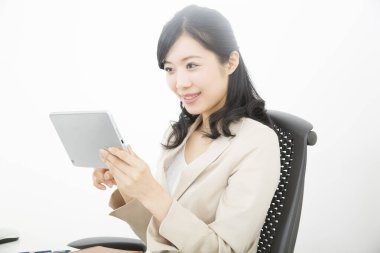 Ofiste dijital tablet kullanan Asyalı iş kadını 