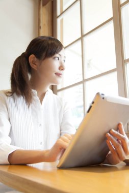 Ofiste tablet kullanan genç bir kadın.