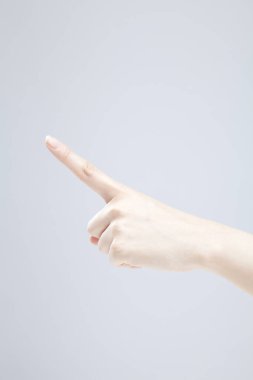 Beyaz arka planda el hareketi yapan kadınların yakın çekimi. 