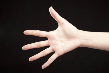 Siyah stüdyo arka planında kadın eli hareketi, yakın çekim. 