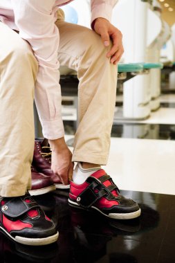 Adam spor ayakkabılarını giyiyor. Yakından. 