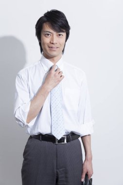 Beyaz arka planda poz veren Asyalı iş adamının portresi 