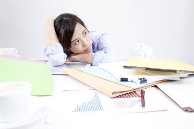 Merkez büroda çalışan genç bir kadın, masasında belgelerle oturuyor.