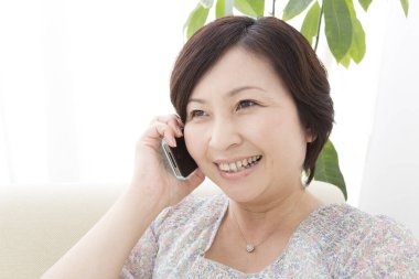 Evde akıllı telefon kullanan bir kadın.