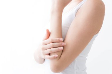 Genç Asyalı kadın koluna dokunuyor.  