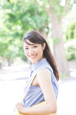 Parktaki Asyalı kadın gülümsüyor 