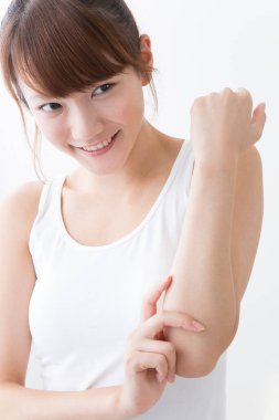 Ön koluna dokunan genç Asyalı kadın beyaz arka planda izole edilmiş..