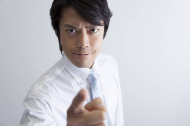 Asyalı bir iş adamının portresi beyaz arka planı işaret ediyor. 