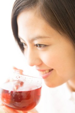 Asyalı kız bir bardak çay içiyor.