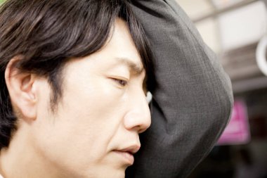 Asyalı adam trenle gidiyor. 