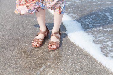 Kumsalda uzun etek giyen genç bir kadının alçak görünümü