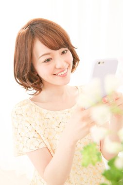Akıllı telefon kullanan güzel bir Japon genç kadın.