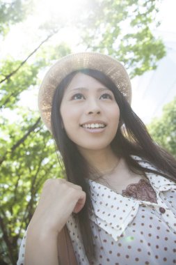 Güzel gülümseyen Asyalı kadın sokakta poz veriyor.