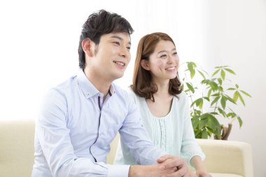 Genç çift oturma odasında birlikte oturuyor.