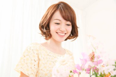 Çiçeklerle gülümseyen güzel Asyalı kadın