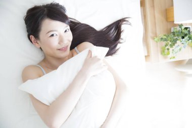 Genç kadın yatakta dinleniyor.