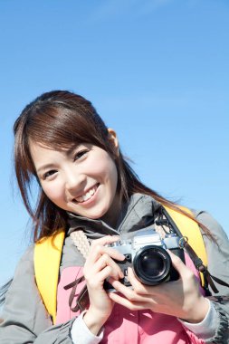 Kamerayla fotoğraf çeken Asyalı kadın.