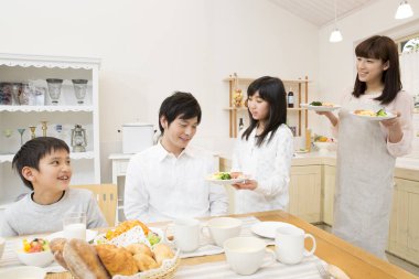 Japon ailesi ev mutfağında kahvaltı yapıyor.