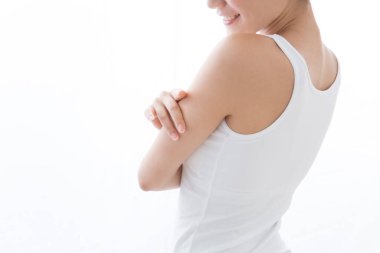 Ön koluna dokunan genç Asyalı kadın beyaz arka planda izole edilmiş..