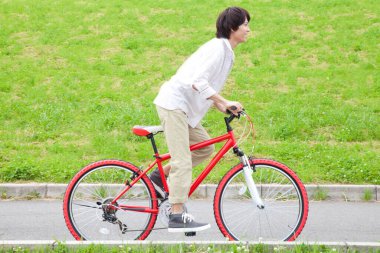 Dışarıda bisikleti olan genç bir adam.