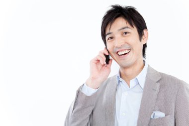 Beyaz arka planda cep telefonuyla konuşan iş adamı 