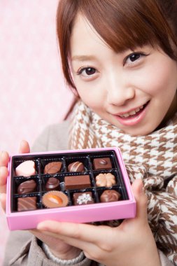 Çikolata kutusu olan Asyalı genç bir kadın. 