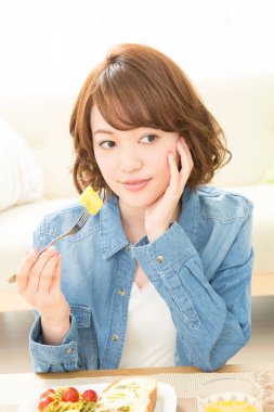 Genç Japon kadın kahvaltısını evde yapıyor.