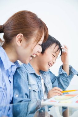 Genç Japon kadın oğluyla ev ödevi yapıyor.