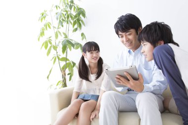 Üç kişilik genç bir aile tablet kullanıyor.