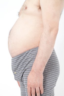 İç çamaşırlı şişman adam karnında yağ birikintisi gösteriyor. Uygun beslenme ve yerleşik yaşam tarzı kavramı 