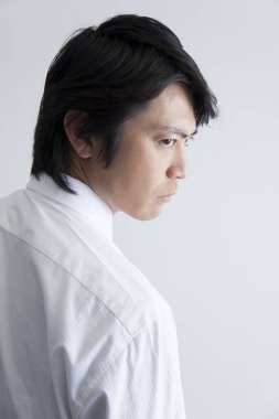 Asyalı annenin portresi, ciddi bir ifadeyle, beyaz arkaplan