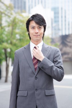 Asyalı iş adamı kameraya bakıyor. 