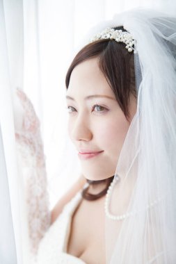 Pencere kenarında duvağı olan güzel Japon gelini.