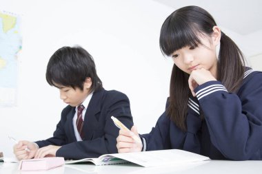 Asyalı öğrenciler sınıfta okuyor.