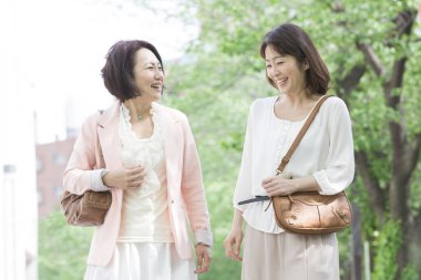 Parkta yürüyen mutlu Asyalı kadınlar 