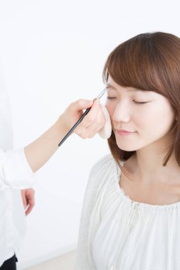 Güzellik salonunda makyaj yapan Asyalı güzel bir kadının yakın çekimi. 