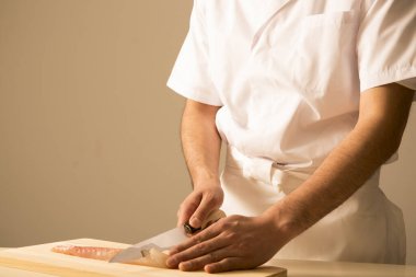 Şef suşi hazırlıyor, balık kesiyor. 