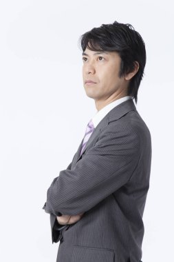 İzole edilmiş arka planda çapraz kollarla yukarı bakan işadamı 