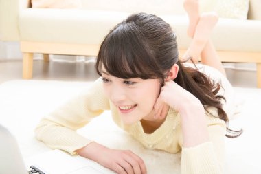 Asyalı iş kadını evde dizüstü bilgisayar kullanıyor. 