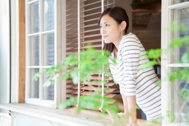 Kadın pencerenin önünde dikiliyor.