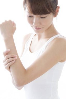 Ön koluna dokunan genç Asyalı kadın beyaz arka planda izole edilmiş..